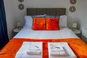 a bedroom with a bed with two towels on it at Artistic & Modern Design Humphreys Lodge - Sleep 6 in Chesterton