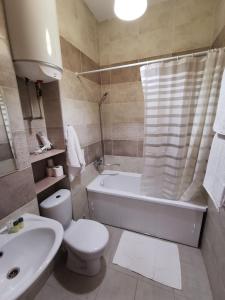 y baño con aseo, bañera y lavamanos. en Apartment Avtorski Riviera, en Fontanka