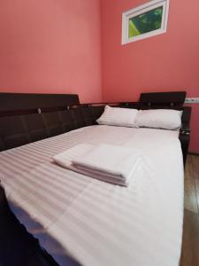Una cama con sábanas blancas y toallas blancas. en Apartment Avtorski Riviera, en Fontanka