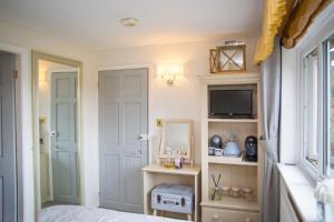 a bedroom with a bed and a mirror and a tv at The Cottage Tea Room B&B in Kettlewell