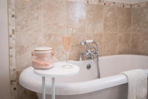 a bathroom with a bottle of champagne and a glass on a table at The Cottage Tea Room B&B in Kettlewell