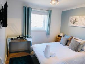 a bedroom with a large white bed with a window at Beautiful 3 Bedroom Apt, mins from Glasgow Airport, M8 & SEC in Paisley