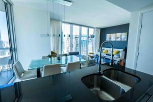 a kitchen with a sink and a table with chairs at Icon Brickell -LUX 2 Bedroom with City & Bayview in Miami
