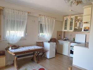 a kitchen with a table and a white refrigerator at DELIA in Međugorje