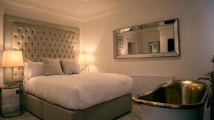 a bedroom with a bed with a mirror and a tub at The Hotel Chester in Chester