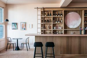 a bar with chairs and a table in a room at Port Hotel in Eastbourne