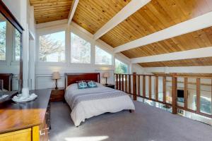 1 dormitorio con 1 cama en una habitación grande con techos de madera. en Otter's Rest, en Gualala