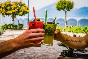 dos personas sosteniendo bebidas en sus manos en Hotel Caribe - Garda Lake Collection, en Brenzone sul Garda