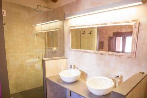 a bathroom with two white sinks and a shower at Masia Les Apieres in El Pla de Manlleu