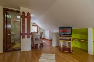 uma sala de estar com televisão e uma sala de jantar em Apartmani Nika em Zlatibor