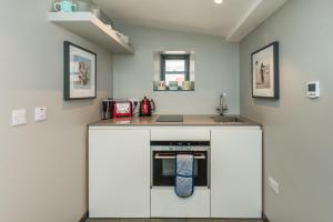 a kitchen with white cabinets and a sink and a counter at Garden Rooms Edinburgh in Edinburgh