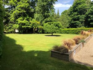 a garden with a park with a tree and grass at Rossal House Apartments, Inverness, Highlands in Inverness