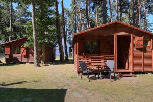 a cabin with a table and chairs in front of it at Domki Letniskowe Kaprys in Pobierowo