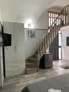ein Wohnzimmer mit einer Treppe und einem TV in der Unterkunft Sicily house in Catania