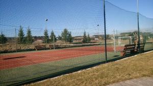 um campo de ténis com uma rede e um banco em Apartmán Tatry C3D2 em Veľká Lomnica