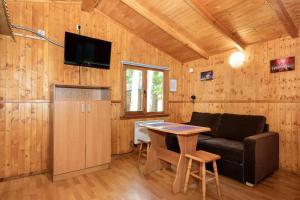 a living room with a couch and a table at Domki Letniskowe Kaprys in Pobierowo