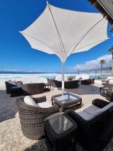 a group of chairs and an umbrella on the beach at Europe Villa Cortes GL in Playa de las Americas