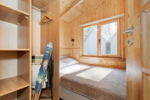 a small room with a bed and a window at Domki Letniskowe Kaprys in Pobierowo