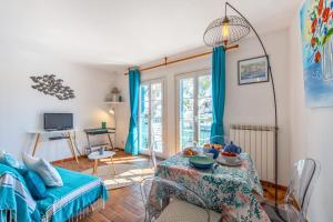 a living room with a table and blue curtains at Appartement Saphir - Welkeys in Grimaud