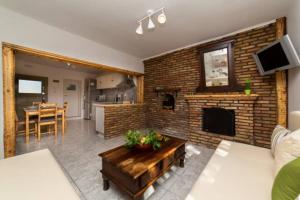 salon z kominkiem z cegły i stołem w obiekcie STATHI'S COTTAGE w mieście Divarata