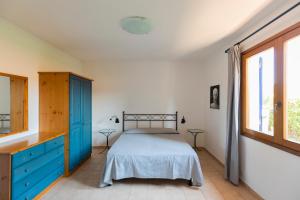ein Schlafzimmer mit einem Bett und einer blauen Kommode in der Unterkunft Villa le Palme in Capoliveri