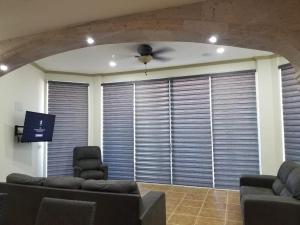 una sala de estar con una gran ventana con persianas en ESMERALDA B-201, en Puerto Peñasco