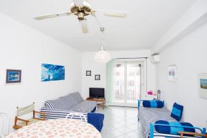 a living room with two couches and a ceiling fan at Casa Malu in Marina di Campo +10 photos