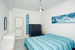 a bedroom with a bed with a blue striped blanket at Casa Malu in Marina di Campo