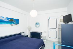 a bedroom with a blue bed and a tv at Casa Malu in Marina di Campo