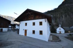 a white building with a brown roof at Landhaus Waldesruh in Oetz