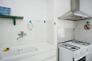 a white kitchen with a stove and a sink at Casa Malu in Marina di Campo