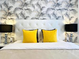 1 dormitorio con cama blanca y almohadas amarillas en Palacio Apartments Madrid, en Madrid