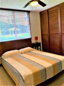 Un dormitorio con una cama grande con una ventana grande. en Condominios Costa Linda, en Jacó 4 fotos más