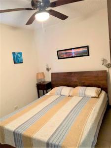 Un dormitorio con una cama con ventilador de techo. en Condominios Costa Linda, en Jacó