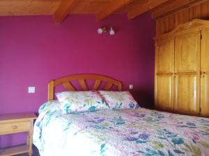 1 dormitorio con cama y pared púrpura en Dúplex Vallespín, en Ávila