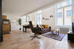 a living room with a couch and a table at LocationsTourcoing - Le Loft in Tourcoing