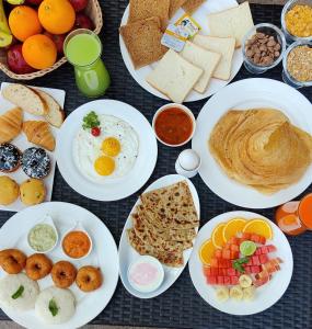 - une table avec des assiettes de produits pour le petit-déjeuner et des boissons dans l'établissement Regenta Resort Belagavi, à Belgaum