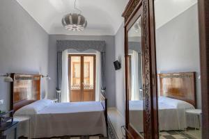 una camera con due letti e uno specchio di Dimora La Torre Room a Favignana