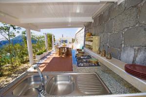 a kitchen with a sink and a stone wall at Amore Rentals - Villa Ligea in SantʼAgata sui Due Golfi