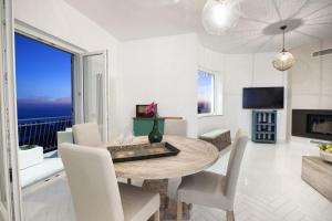 a dining room with a table and a view of the ocean at Amore Rentals - Villa Ligea in SantʼAgata sui Due Golfi