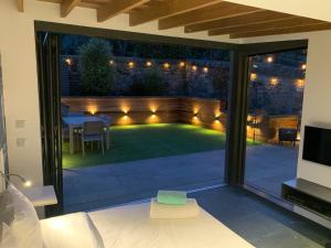 einen Garten mit einer Terrasse und einer Liegewiese mit Licht in der Unterkunft Garden Rooms Edinburgh in Edinburgh