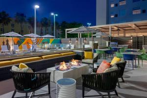 d'une terrasse avec un foyer extérieur, des chaises et des tables. dans l'établissement Hyatt House Tampa Airport/Westshore, à Tampa