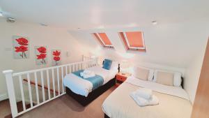 a bedroom with two beds and two windows at Cedar Villa - Perfect For Longer Stays in Chatham