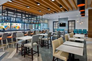 a restaurant with tables and chairs and a bar at Hyatt House Tampa Airport/Westshore in Tampa