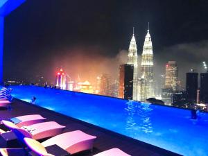 a swimming pool with a view of the city at night at Platinum Serviced Suite KLCC in Kuala Lumpur