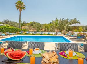 a table with food and fruit next to a swimming pool at Villa Riviera by Algarve Vacation in Armação de Pêra