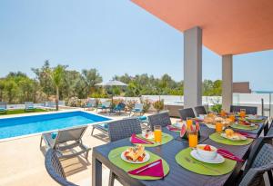 a patio with a table with food and a pool at Villa Riviera by Algarve Vacation in Armação de Pêra