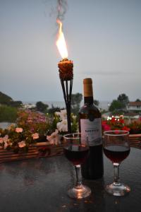 una botella de vino y dos copas en una mesa con una vela en Gardenos Mamas Reas, en Vitalades