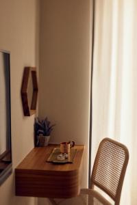 un piccolo tavolo in legno con una sedia e una tazza sopra di Sunlight Homestay a Magong