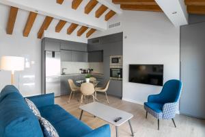 a living room with a blue couch and a table at Arenal Suites Alicante in Alicante